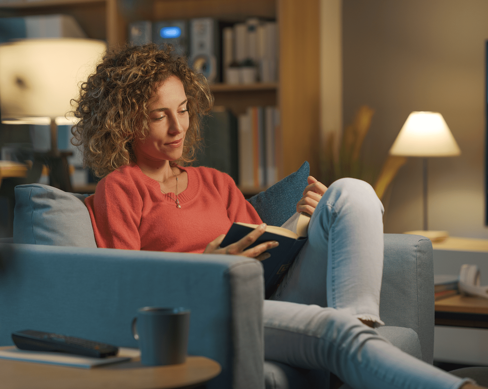 Woman reading a book on couch.